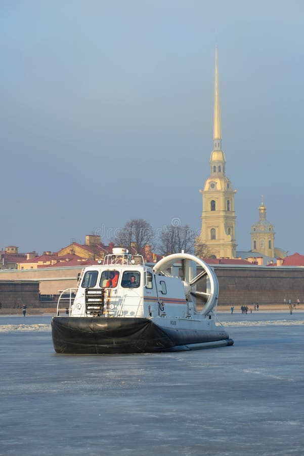 Räddningsaktionfartyget av Emercom av ` för Ryssland ` Hivus-20 mot bakgrunden av Peter och Paul Cathedral på is av den djupfryst arkivfoto Räddningsaktionfartyget av Emercom av ` för Ryssland ` Hivus-20 mot bakgrunden av Peter och Paul Cathedral på is av den djupfryst arkivfoto