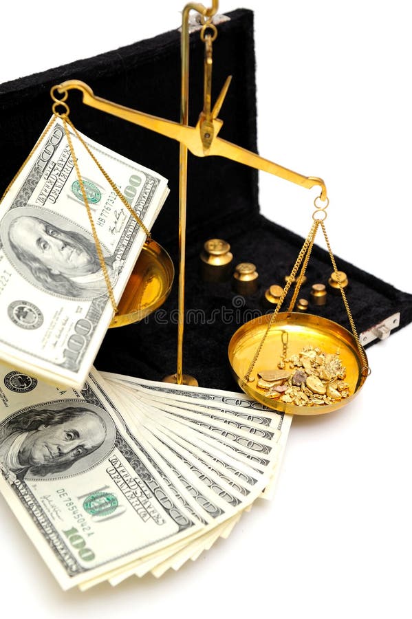 Gold nuggets in the pan of a balance scale with many fifty and hundred dollar bills showing the value of both. Gold nuggets in the pan of a balance scale with many fifty and hundred dollar bills showing the value of both