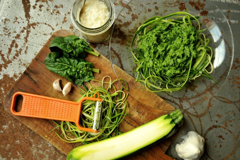 Rå pasta med zucchini- och spenatpesto med vitlök arkivbilder Rå pasta med zucchini- och spenatpesto med vitlök arkivbilder