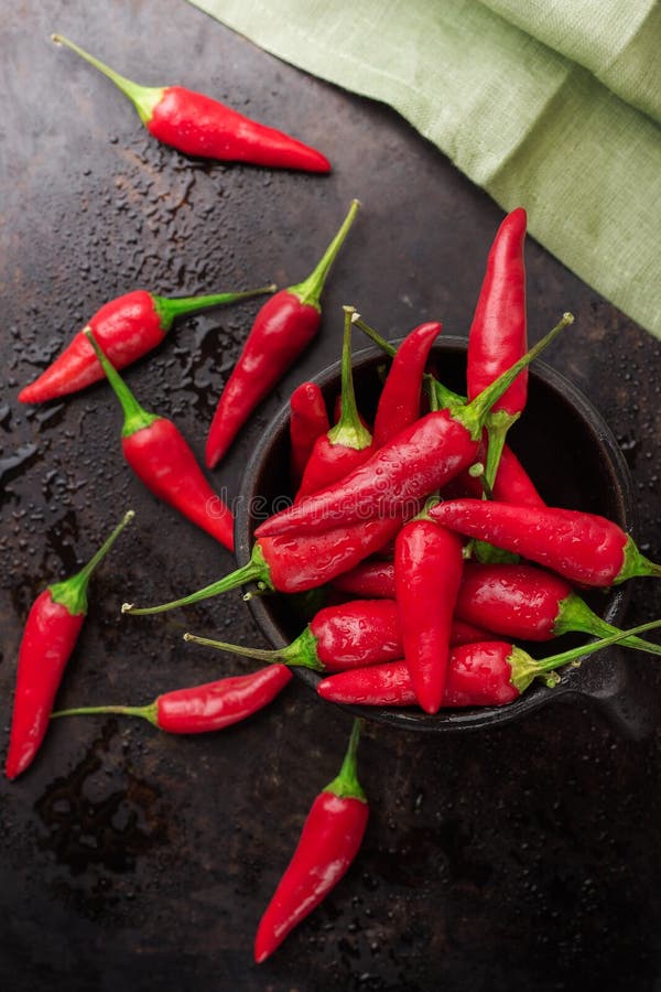 Rå röda mexikanska chilipeppar på en svart rostig tabell fotografering för bildbyråer Rå röda mexikanska chilipeppar på en svart rostig tabell fotografering för bildbyråer