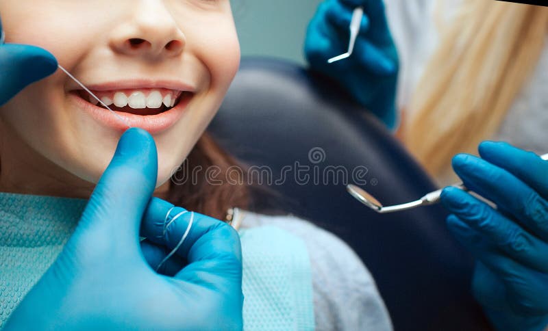 Rżnięte widok ręki w lateksowych rękawiczkach floss dziecko frontowych zęby Kobieta chwyta stomatologiczni narzędzia obok