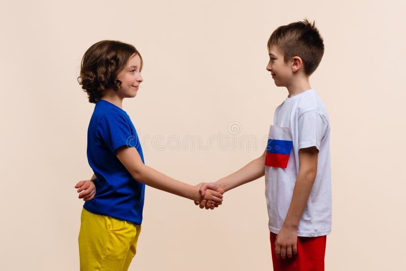 Boy and Girl in Outfits in Colors Flags Russia and Ukraine Look each Other and Make Handshake. Reconciliation, end conflict and stop war. Friendship of Fraternal Peoples. Cousins want peace. Boy and Girl in Outfits in Colors Flags Russia and Ukraine Look each Other and Make Handshake. Reconciliation, end conflict and stop war. Friendship of Fraternal Peoples. Cousins want peace