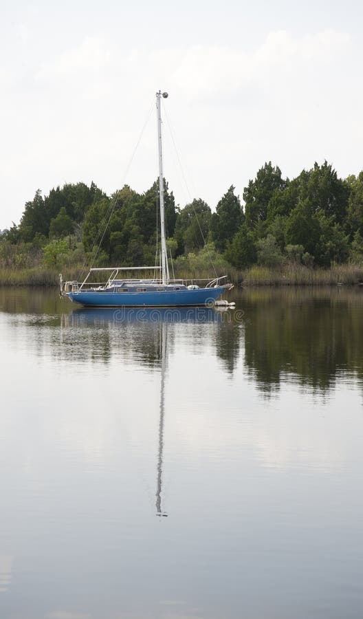 A lone sailboat moored in the Waccamaw River in Georgetown South Carolina. A lone sailboat moored in the Waccamaw River in Georgetown South Carolina