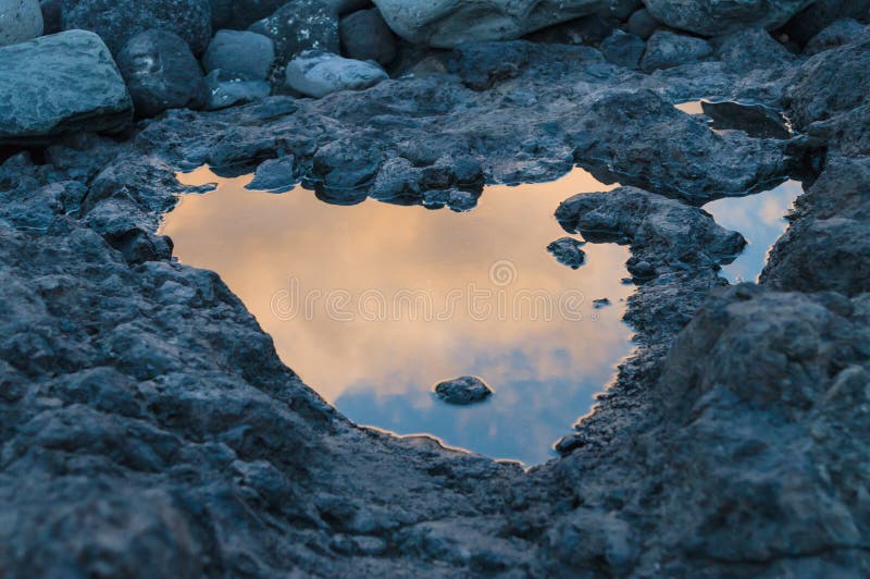 Réflexion de coucher du soleil dans le petit magma sur la terre volcanique photos libres de droits Réflexion de coucher du soleil dans le petit magma sur la terre volcanique photos libres de droits