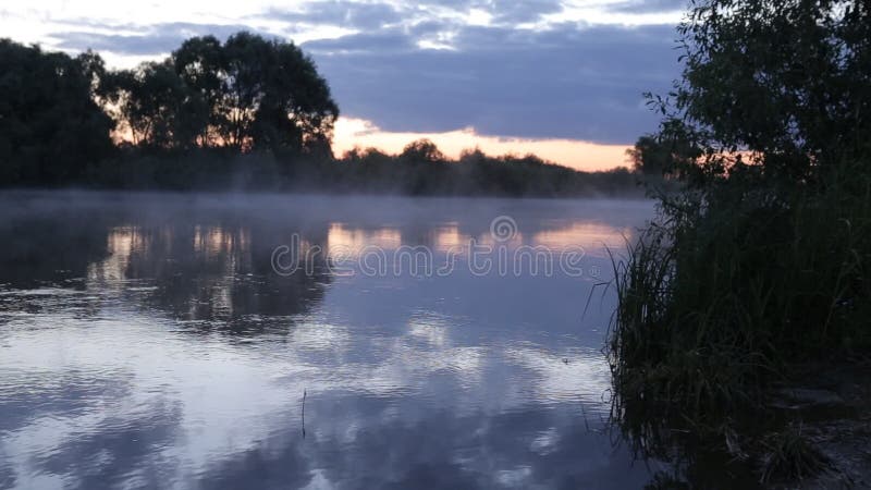 Réflexion de lever de soleil de matin dans la hausse brumeuse de brouillard de l'eau de rivière débordante