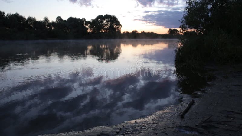 Réflexion de lever de soleil de matin dans la hausse brumeuse de brouillard de l'eau de rivière débordante