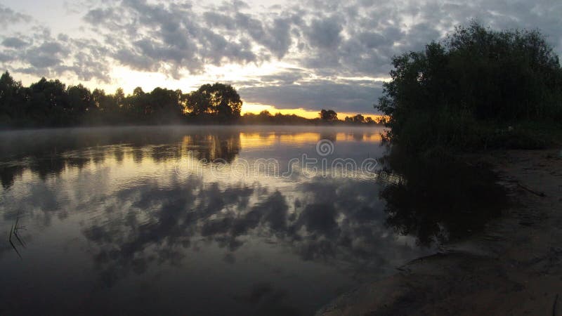 Réflexion de lever de soleil de matin dans la hausse brumeuse de brouillard de l'eau de rivière débordante
