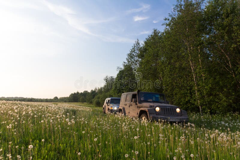 Région de Novgorod, la Russie, le 30 avril 2016, un voyage à Hummer H3 et à Jeep Wrangler sur le champ, Hummer H3 et la jeep images stock Région de Novgorod, la Russie, le 30 avril 2016, un voyage à Hummer H3 et à Jeep Wrangler sur le champ, Hummer H3 et la jeep images stock