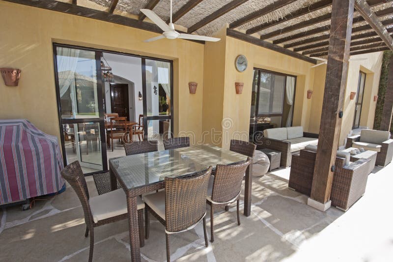 Région de patio avec le sofa et la table de salle à manger à un holid tropical de luxe photo stock Région de patio avec le sofa et la table de salle à manger à un holid tropical de luxe photo stock