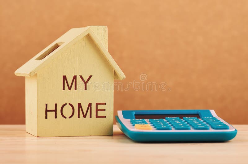 Réplica e calculadora da casa na mesa de madeira para o empréstimo hipotecário e o financiamento fotos de stock royalty free Réplica e calculadora da casa na mesa de madeira para o empréstimo hipotecário e o financiamento fotos de stock royalty free