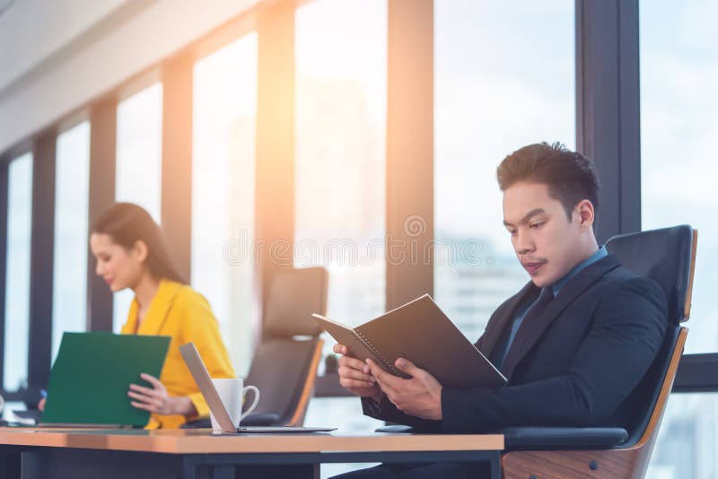 Réservation exécutive de rapport de lecture de directeur commercial dans le bureau de matin photo stock Réservation exécutive de rapport de lecture de directeur commercial dans le bureau de matin photo stock