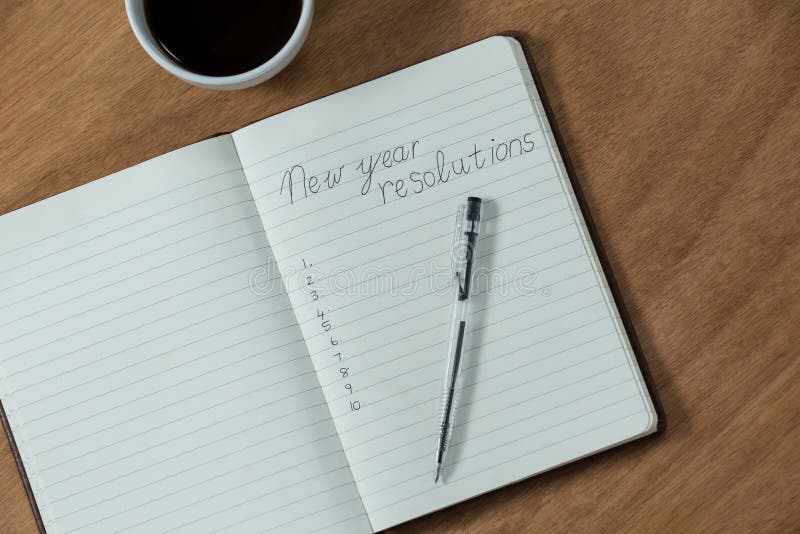 Résolutions de nouvelle année écrites sur le journal intime avec la tasse de café photos libres de droits Résolutions de nouvelle année écrites sur le journal intime avec la tasse de café photos libres de droits