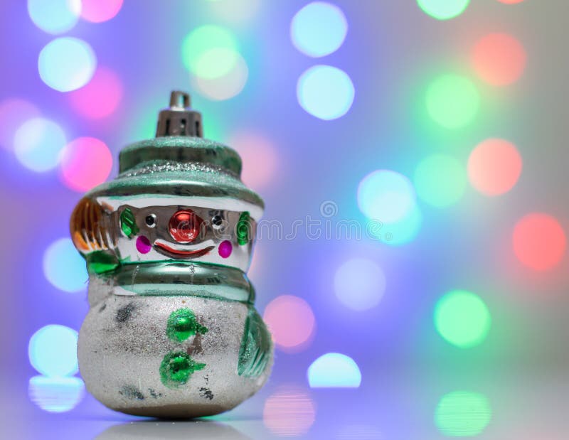 Rétro bonhomme de neige de jouet de Noël dans le bokeh de fond photographie stock Rétro bonhomme de neige de jouet de Noël dans le bokeh de fond photographie stock