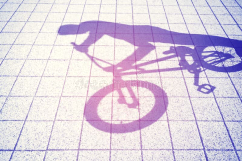 Rétro ombre brouillée modifiée la tonalité d'un adolescent montant un vélo de bmx