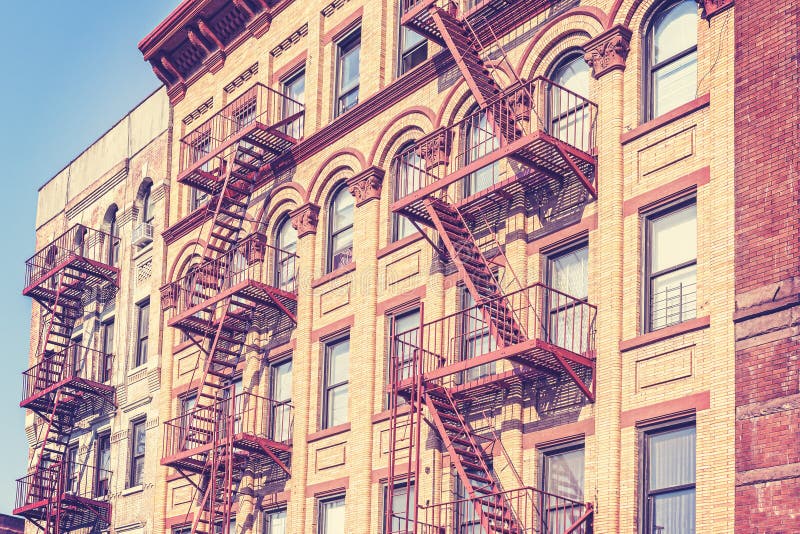 Rétro photo modifiée la tonalité de vieux film du bâtiment de New York avec la sortie de secours images stock Rétro photo modifiée la tonalité de vieux film du bâtiment de New York avec la sortie de secours images stock