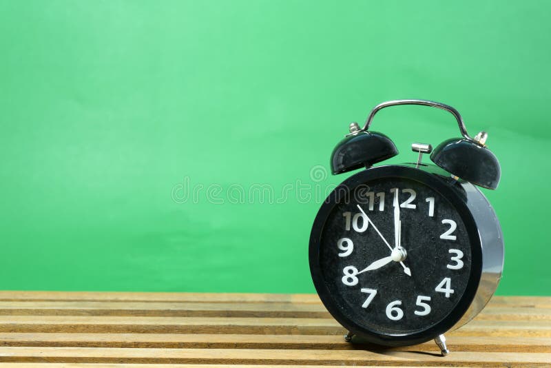 Rétro réveil sur la table sur le fond vert en bon état images libres de droits Rétro réveil sur la table sur le fond vert en bon état images libres de droits