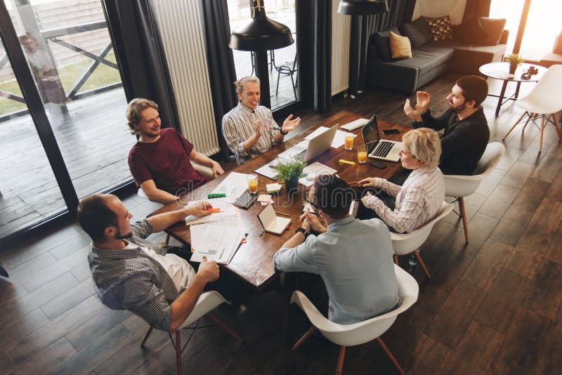 Réunion de Coworking Les gens d'affaires de groupe s'asseyent autour de la table et du W photo stock