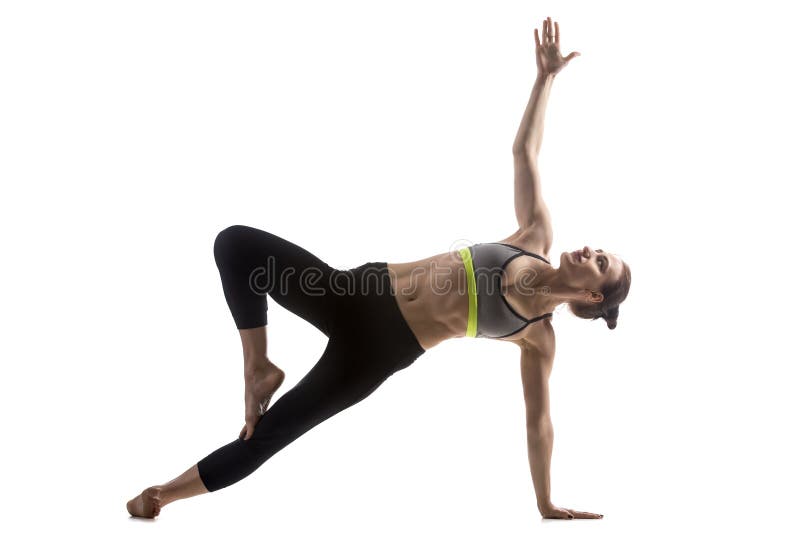 Portrait of sporty fit beautiful young brunette woman in sportswear working out, doing variation of Side Plank Posture, Pose Vasisthasana, studio full length, isolated shot on white background. Portrait of sporty fit beautiful young brunette woman in sportswear working out, doing variation of Side Plank Posture, Pose Vasisthasana, studio full length, isolated shot on white background