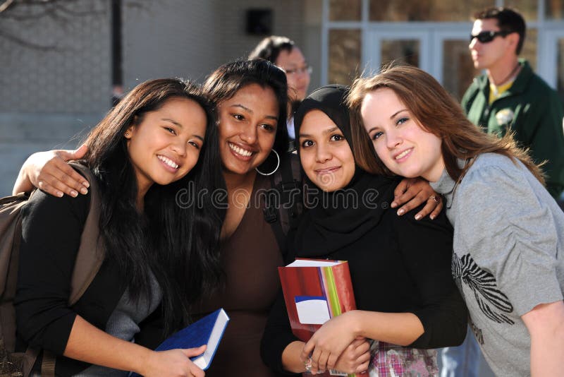 Group of diverse students in a group with others in the background. Group of diverse students in a group with others in the background