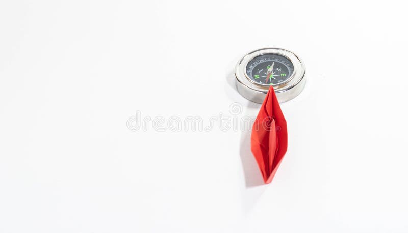 selective focus of a pink paper boat and a compass marking the north, concept of women's leadership on international women's day and rights. selective focus of a pink paper boat and a compass marking the north, concept of women's leadership on international women's day and rights