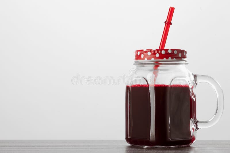 Röd fruktsaft i den glass kruset på vit bakgrund arkivbilder Röd fruktsaft i den glass kruset på vit bakgrund arkivbilder