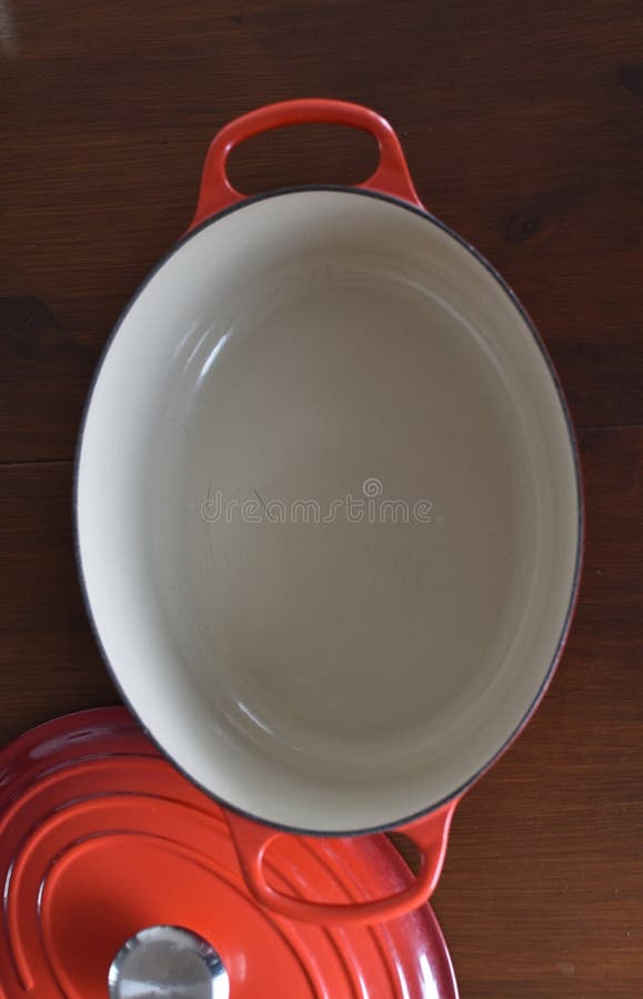 Röd gjutjärnsoval saucepan med lock royaltyfri foto