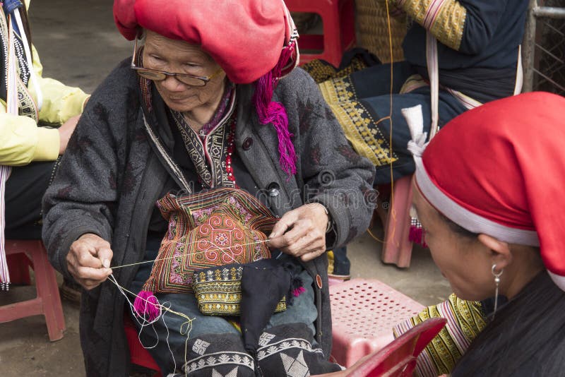 R?d kvinna f?r etnisk minoritet f?r dzao som syr i Sa-PA, Lao Cai landskap, Vietnam den ?ldre kvinnan g?r souvenir p? gatan fotografering för bildbyråer R?d kvinna f?r etnisk minoritet f?r dzao som syr i Sa-PA, Lao Cai landskap, Vietnam den ?ldre kvinnan g?r souvenir p? gatan fotografering för bildbyråer