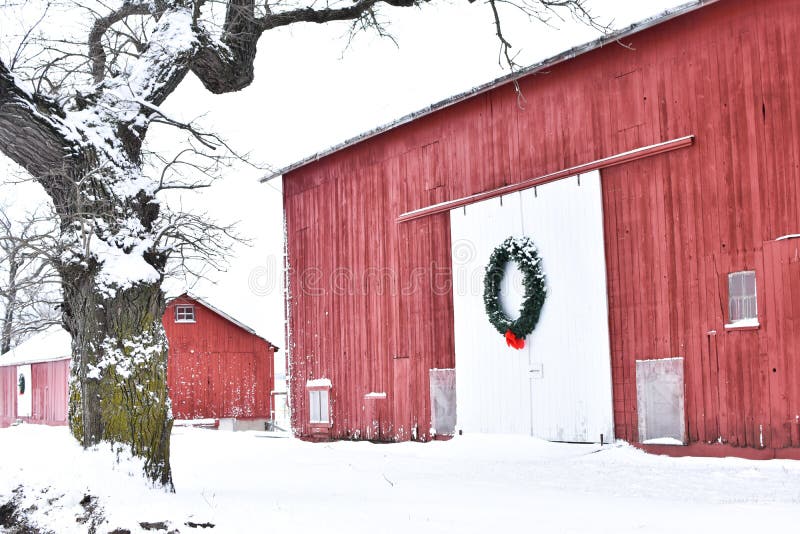 Röd ladugård i vinter med en julkrans arkivbild Röd ladugård i vinter med en julkrans arkivbild