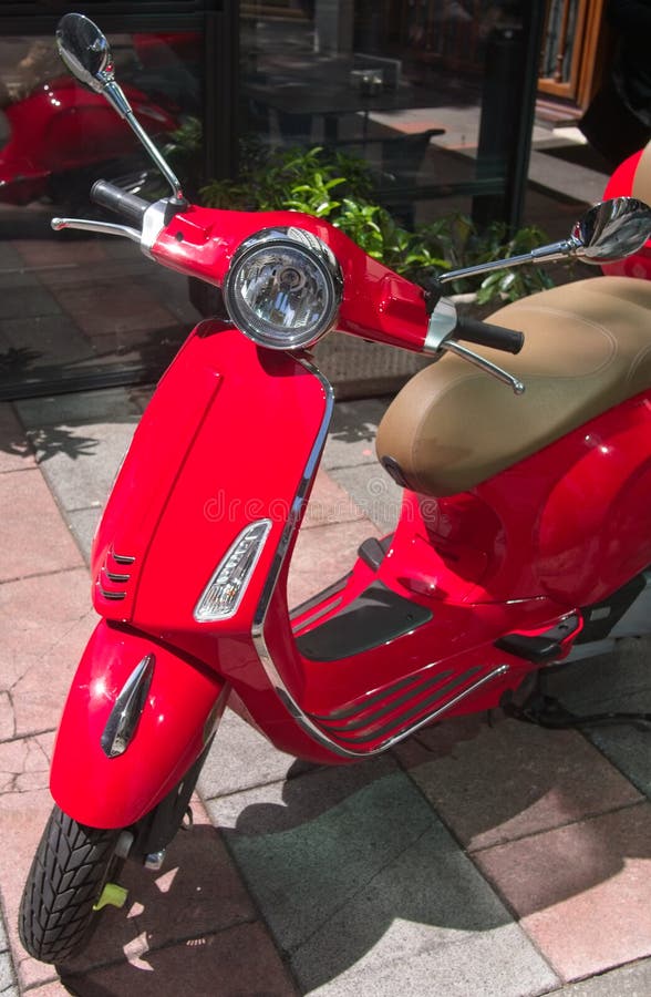 Röd retro italiensk stilsparkcykel som parkeras på gatan royaltyfri fotografi Röd retro italiensk stilsparkcykel som parkeras på gatan royaltyfri fotografi