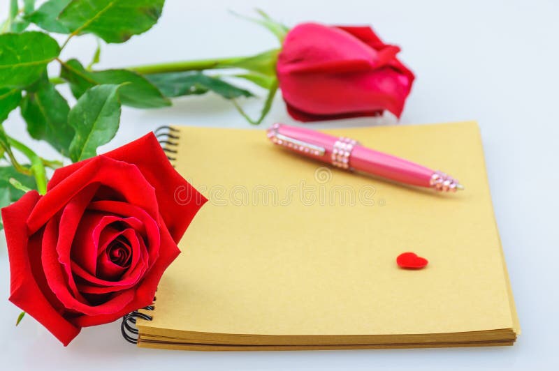 Röd ros- och rosa färgpenna med anteckningsboken Fotoet fokuseras på vänstersidan steg arkivfoton Röd ros- och rosa färgpenna med anteckningsboken Fotoet fokuseras på vänstersidan steg arkivfoton