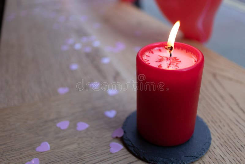 Röd stearinljus som isoleras med rosa hjärtakonfettier royaltyfri foto Röd stearinljus som isoleras med rosa hjärtakonfettier royaltyfri foto