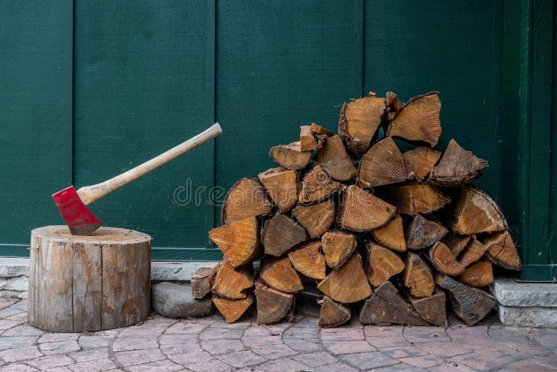 Röd yxa och hög av brandträ arkivfoto Röd yxa och hög av brandträ arkivfoto