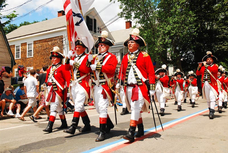 A group of adults, dressed in traditional British red coats, march in the Fourth of July Parade in Bristol, Rhode Island. A group of adults, dressed in traditional British red coats, march in the Fourth of July Parade in Bristol, Rhode Island