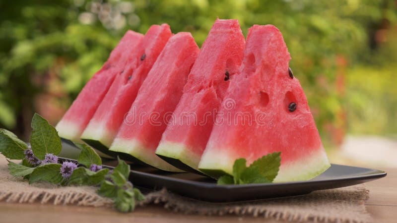 Röda vattenmelonskivor på en platta med mintkaramellsidor