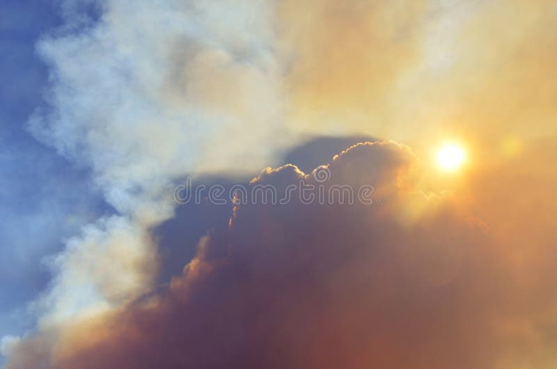 Bushfire smoke rising into the sky and blocking the sun as it sets. Natural disaster, danger and apocalypse concepts. Bushfire smoke rising into the sky and blocking the sun as it sets. Natural disaster, danger and apocalypse concepts.