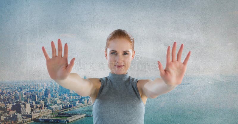 Rörande luft för futuristisk affärskvinna framme av den gråa grungestaden royaltyfria foton