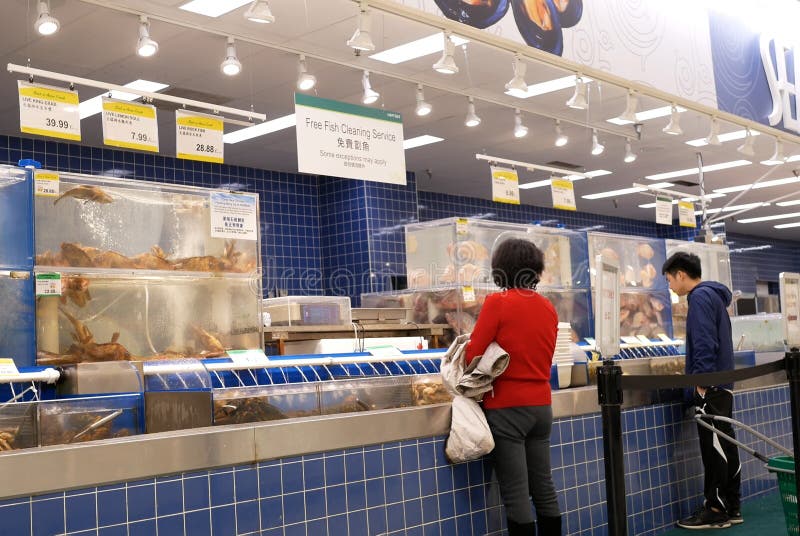 Rörelse av den köpande fisken för folk på det havs- avsnittet inom T&T-supermarket arkivfoton Rörelse av den köpande fisken för folk på det havs- avsnittet inom T&T-supermarket arkivfoton
