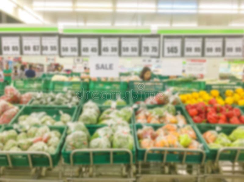 Rörelsesuddighet av frukthyllor som är till salu i supermarket med någon folkshopping royaltyfri fotografi Rörelsesuddighet av frukthyllor som är till salu i supermarket med någon folkshopping royaltyfri fotografi