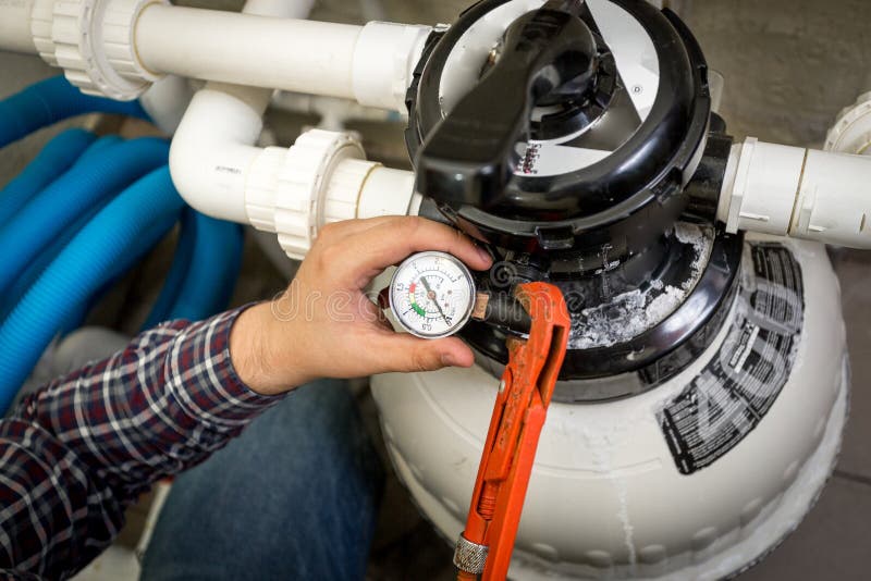 Rörmokare som kontrollerar manometern på den stora hydrauliska pumpen fotografering för bildbyråer Rörmokare som kontrollerar manometern på den stora hydrauliska pumpen fotografering för bildbyråer