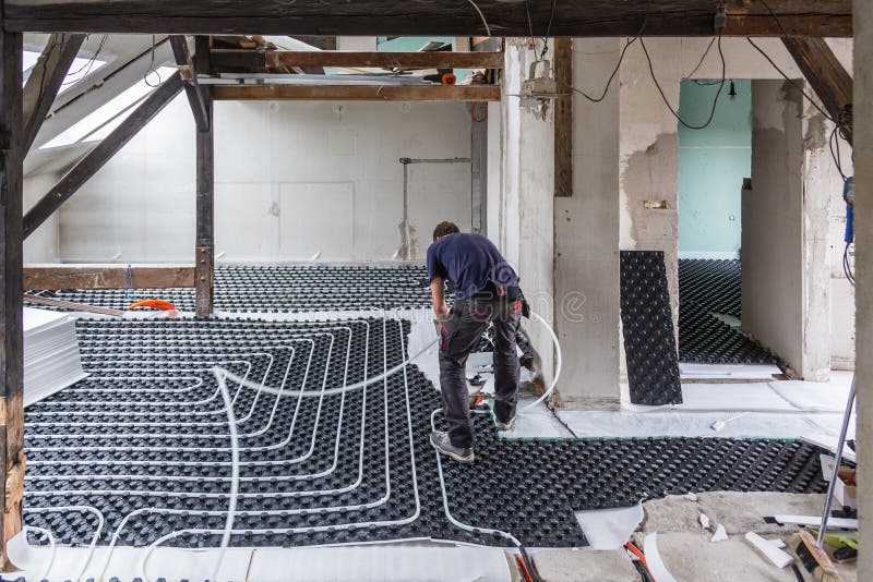 Rörmontör som monterar underfloor uppvärmning royaltyfri foto Rörmontör som monterar underfloor uppvärmning royaltyfri foto
