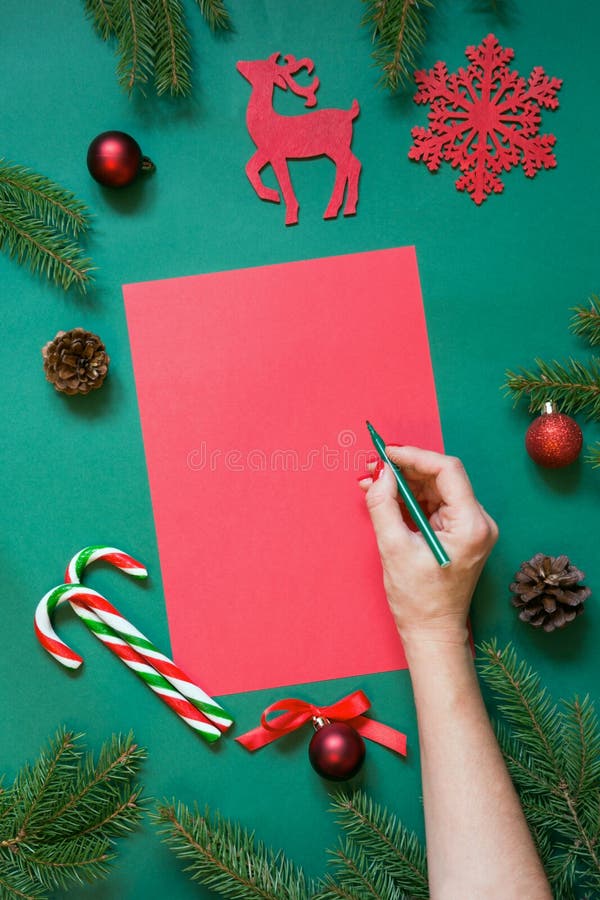 Rött mellanrum för jul för bokstav till jultomten eller dina wishlist- eller adventaktiviteter på gräsplan female hand page writi royaltyfri fotografi Rött mellanrum för jul för bokstav till jultomten eller dina wishlist- eller adventaktiviteter på gräsplan female hand page writi royaltyfri fotografi