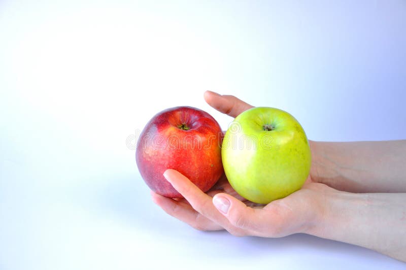 Rött och grönt äpple i händer på vit bakgrund arkivbilder Rött och grönt äpple i händer på vit bakgrund arkivbilder