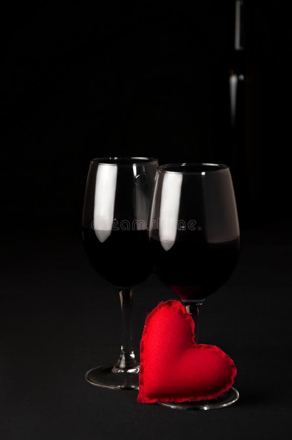 Rött vindrinkalkohol Två exponeringsglas av rött vin och mjuka Toy Heart på svart bakgrund Begreppsromantikermatställe arkivfoto Rött vindrinkalkohol Två exponeringsglas av rött vin och mjuka Toy Heart på svart bakgrund Begreppsromantikermatställe arkivfoto