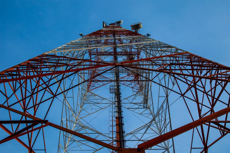 Rött vitt telekommunikationtorn mot blå himmel - nedersta sikt royaltyfri fotografi Rött vitt telekommunikationtorn mot blå himmel - nedersta sikt royaltyfri fotografi