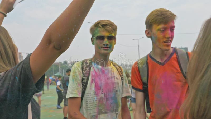 RÚSSIA, IRKUTSK - 27 DE JUNHO DE 2018: Jovens felizes dançando e celebrando durante o Festival das Cores de Holi Multidão