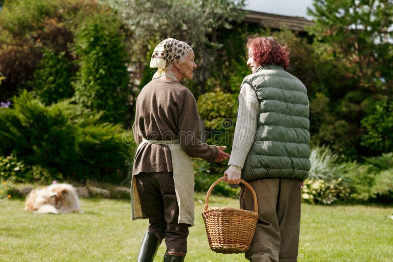 Rückblick auf Mädchen und ihre Großmutter plaudert, während sie auf grünem Rasen herabgeht stockbild