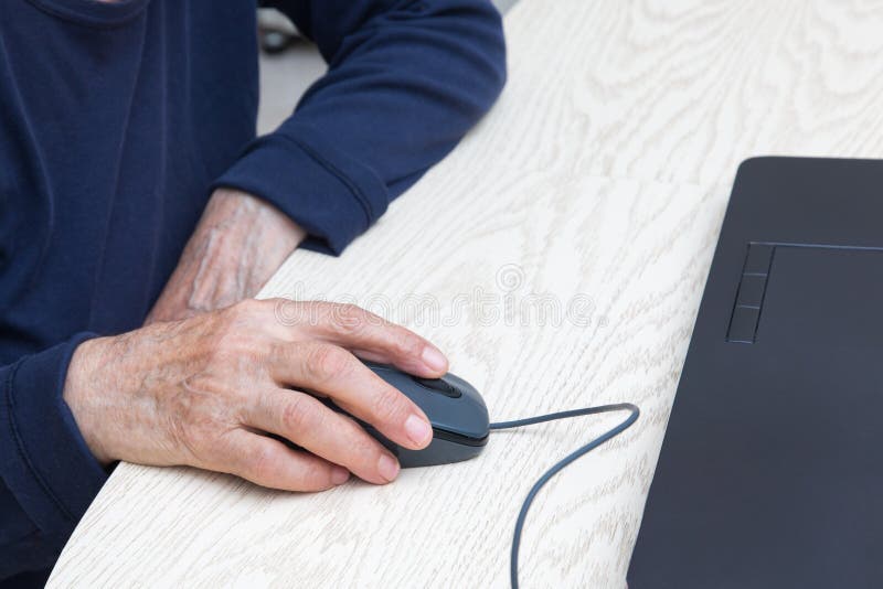 Ręce starszej kobiety z bliska z myszą komputerową przy laptopie zdjęcia stock Ręce starszej kobiety z bliska z myszą komputerową przy laptopie zdjęcia stock