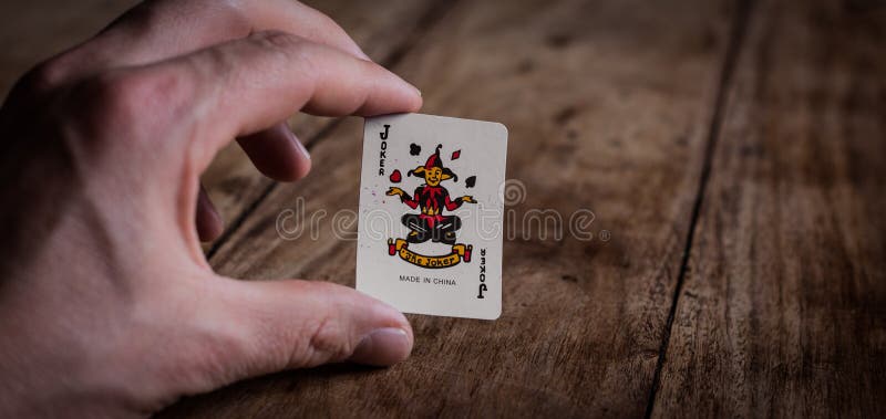 Ręczne trzymanie karty Joker Wild Card | Karty do odtwarzania | Gry hazardowe | Gambler | Gra w pokera zdjęcia royalty free