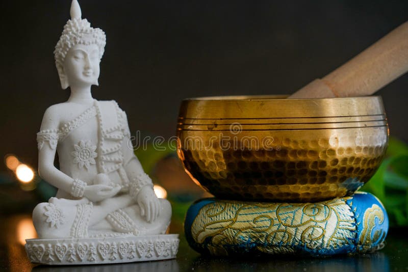 A hand hammered Tibetan bell with Buddha on a black background. A hand hammered Tibetan bell with Buddha on a black background