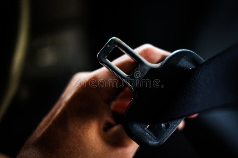 Hand of driver holding seat belt safety belt lock in car before driving - safety & secure concept. Hand of driver holding seat belt safety belt lock in car before driving - safety & secure concept.